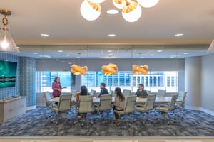 Coworkers sitting at a table in a boardroom in Miami Tower